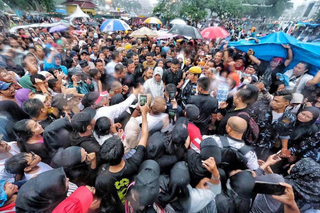 Gibran tetap menyapa pendukung yang tetap menunggu di tengah hujan lebat.